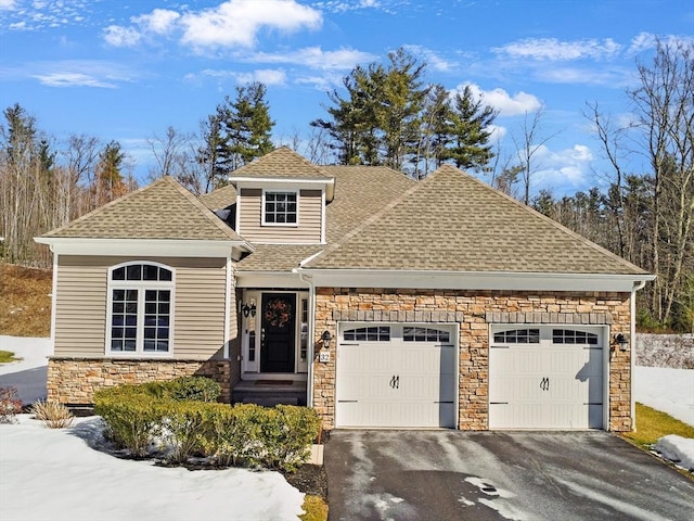 view of front of house with a garage, stone siding, aphalt driveway, and roof with shingles