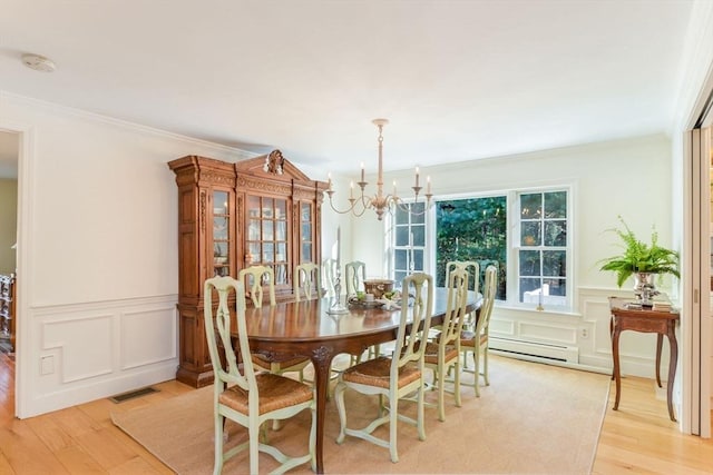 dining room with baseboard heating, crown molding, a notable chandelier, and light wood-type flooring