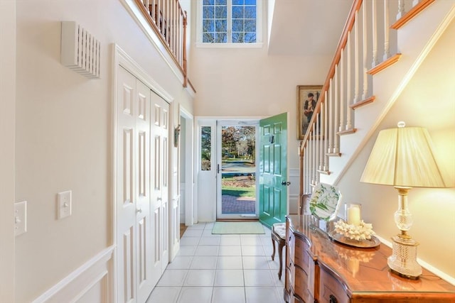 doorway featuring a towering ceiling and light tile patterned floors