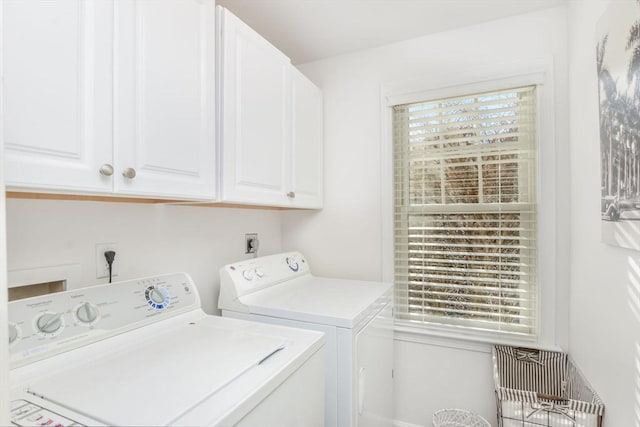 laundry room with separate washer and dryer, cabinets, and a healthy amount of sunlight