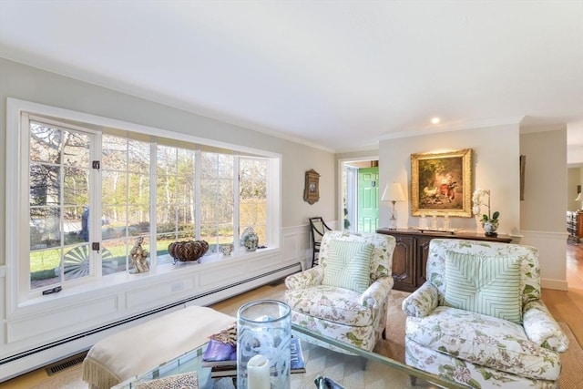 sitting room with light hardwood / wood-style flooring, baseboard heating, and crown molding