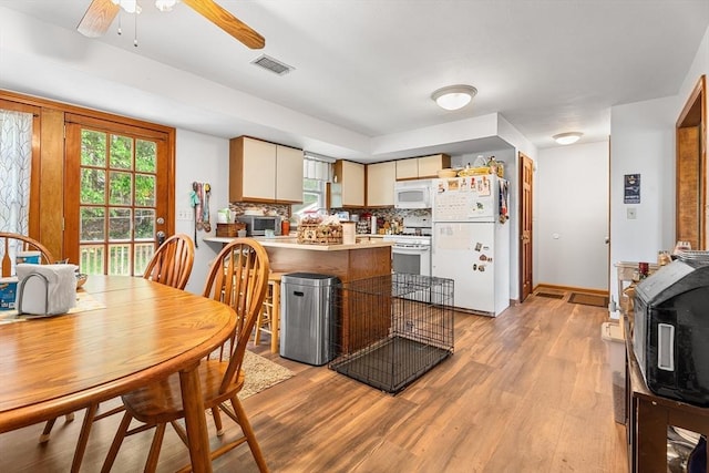 22 Washington St, Methuen, MA 01844 - kitchen with white appliances, plenty of natural light, a peninsula, and light wood-type flooring