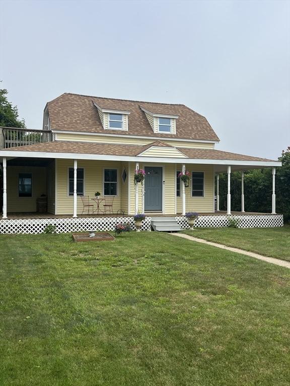 13 Harrison Ave, Bourne, MA 02532 - country-style home with a front yard, a shingled roof, and a porch