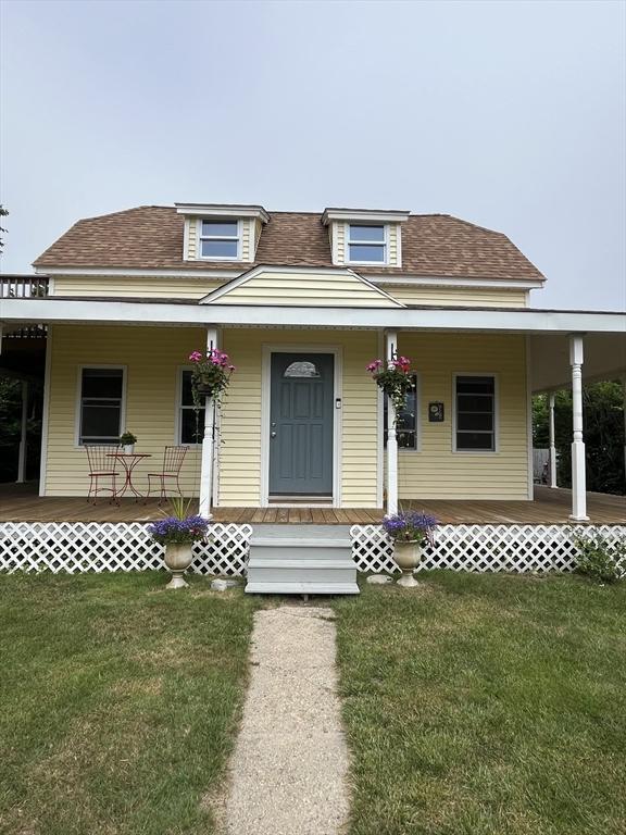 13 Harrison Ave, Bourne, MA 02532 - view of front facade featuring covered porch, roof with shingles, and a front yard