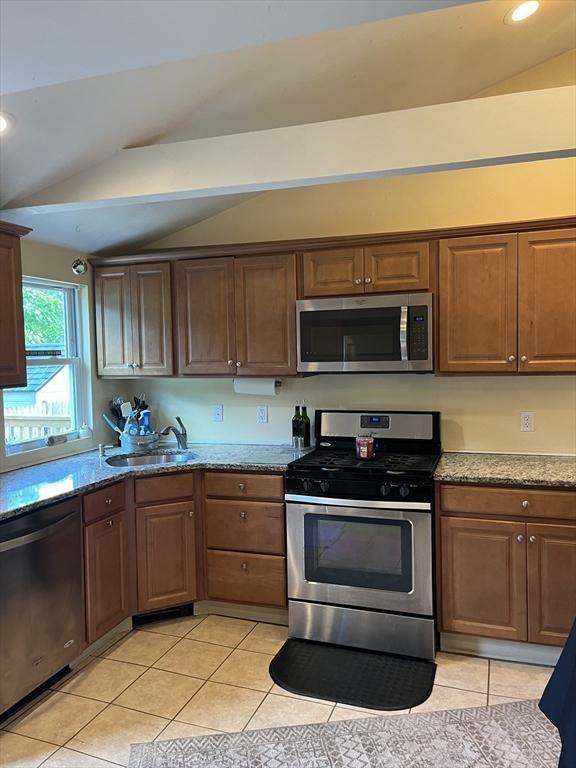 13 Harrison Ave, Bourne, MA 02532 - kitchen with stainless steel appliances, lofted ceiling, light tile patterned floors, light stone counters, and recessed lighting