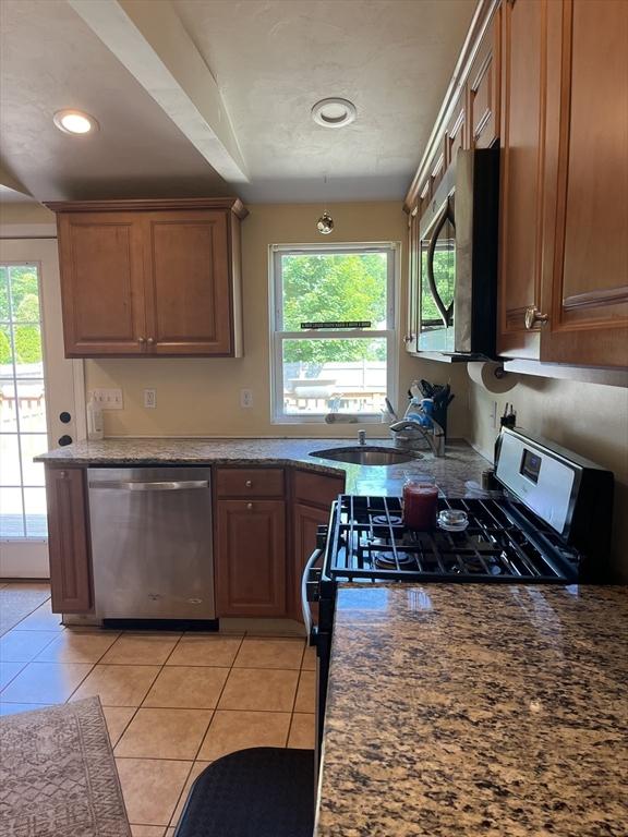 13 Harrison Ave, Bourne, MA 02532 - kitchen with appliances with stainless steel finishes, light tile patterned flooring, brown cabinetry, and recessed lighting