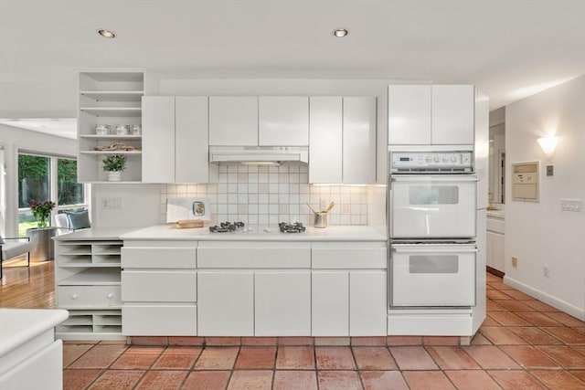 kitchen featuring light countertops, open shelves, under cabinet range hood, and white appliances