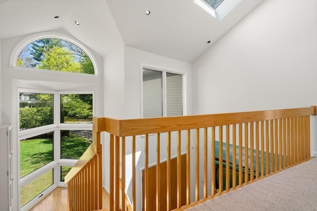 hallway featuring a skylight, high vaulted ceiling, and recessed lighting