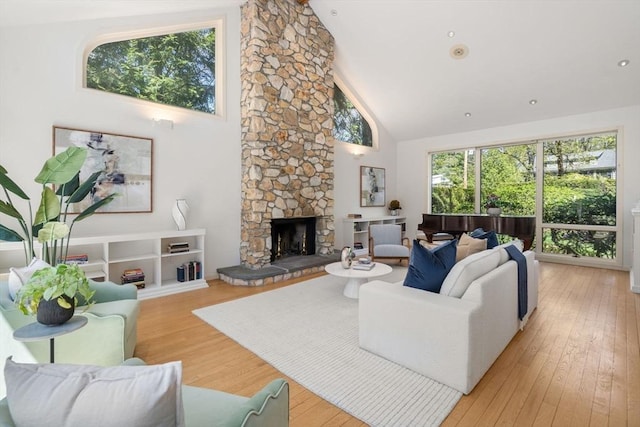 living room with light wood finished floors, a fireplace, and high vaulted ceiling