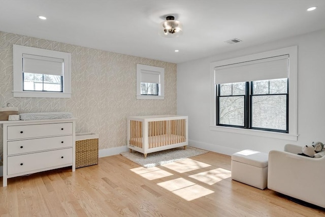 bedroom with recessed lighting, visible vents, light wood-style flooring, baseboards, and wallpapered walls