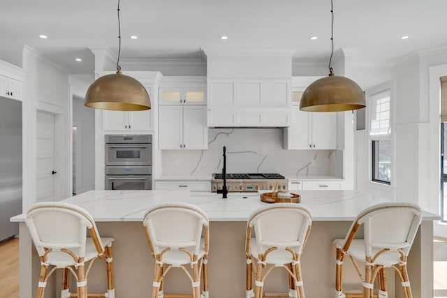 kitchen featuring ornamental molding, appliances with stainless steel finishes, white cabinets, and tasteful backsplash