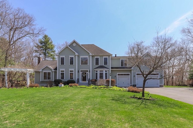 view of front facade featuring an attached garage, a front lawn, and driveway