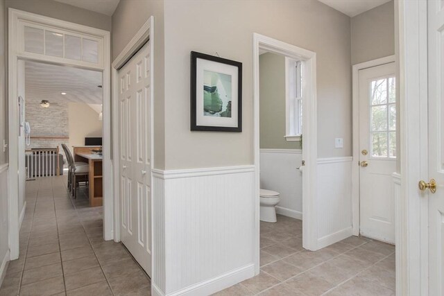 corridor with wainscoting and light tile patterned floors