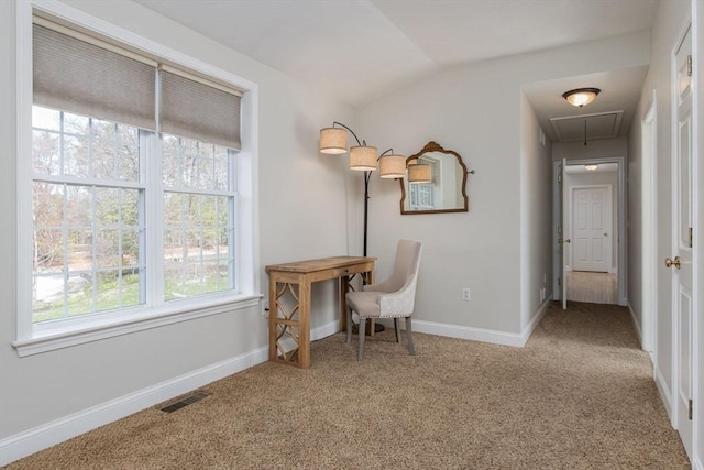 office area with carpet flooring, visible vents, vaulted ceiling, and attic access