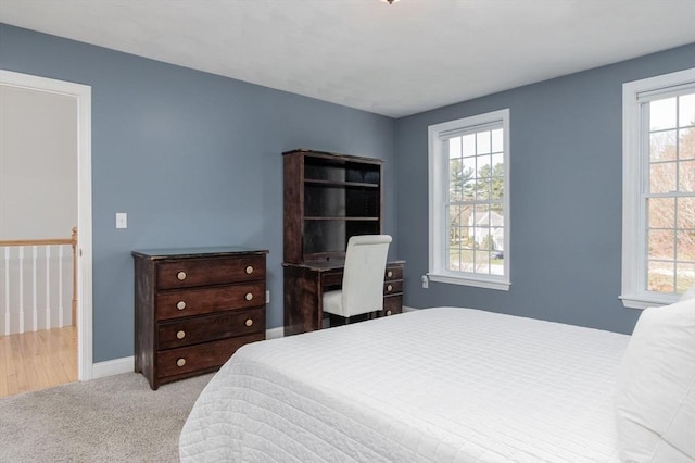 bedroom featuring baseboards, carpet flooring, and multiple windows