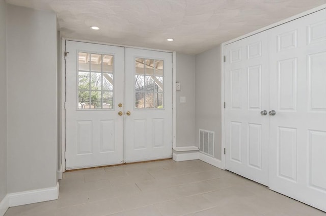 foyer entrance featuring french doors, recessed lighting, baseboards, light tile patterned floors, and visible vents