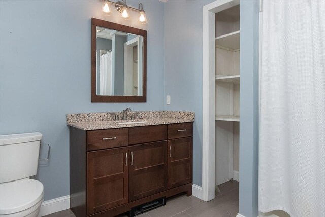 full bathroom with a shower with curtain, baseboards, vanity, and toilet