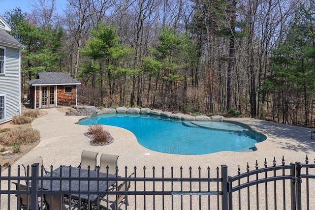 view of swimming pool with a patio, an exterior structure, and fence private yard