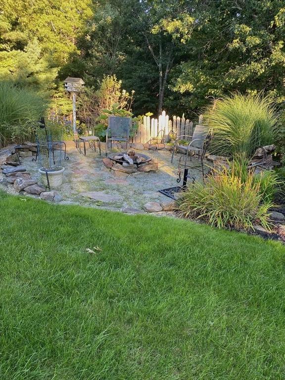 view of yard featuring a patio area, an outdoor fire pit, and fence