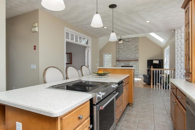 kitchen featuring light tile patterned flooring, open floor plan, a center island, light countertops, and stainless steel appliances