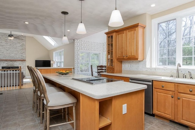 kitchen with stainless steel dishwasher, black electric stovetop, a healthy amount of sunlight, and a kitchen island