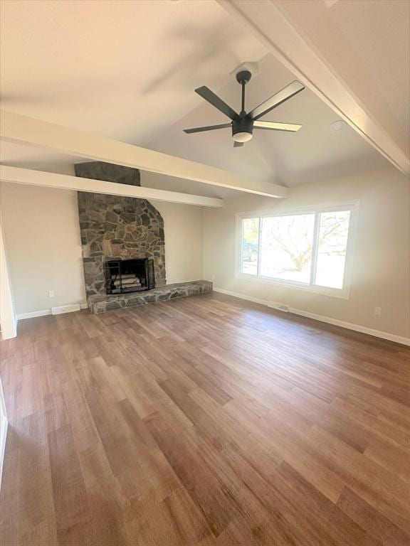 unfurnished living room featuring lofted ceiling with beams, a fireplace, wood finished floors, and a ceiling fan