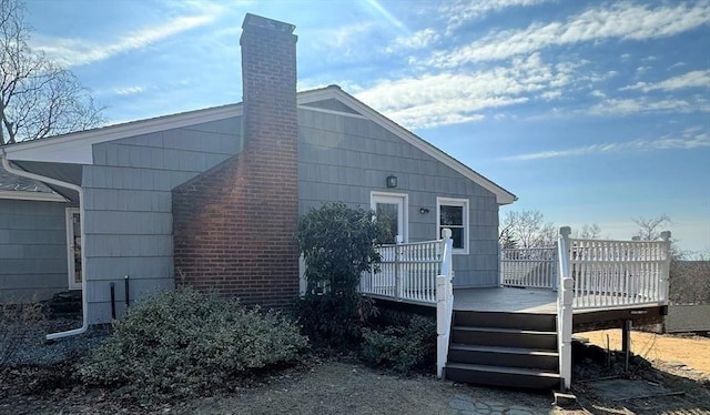 back of property featuring a deck and a chimney