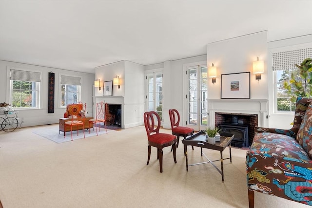 living room featuring a fireplace, carpet, and a healthy amount of sunlight