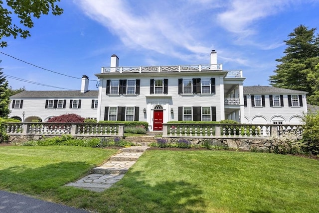 italianate-style house with fence, a chimney, and a front yard