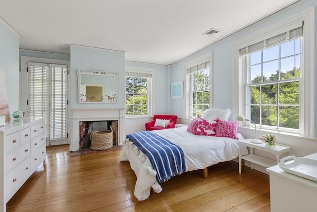 bedroom with light wood finished floors and visible vents