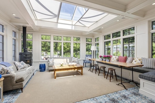 sunroom / solarium with carpet flooring, coffered ceiling, a skylight, a wood stove, and ornamental molding
