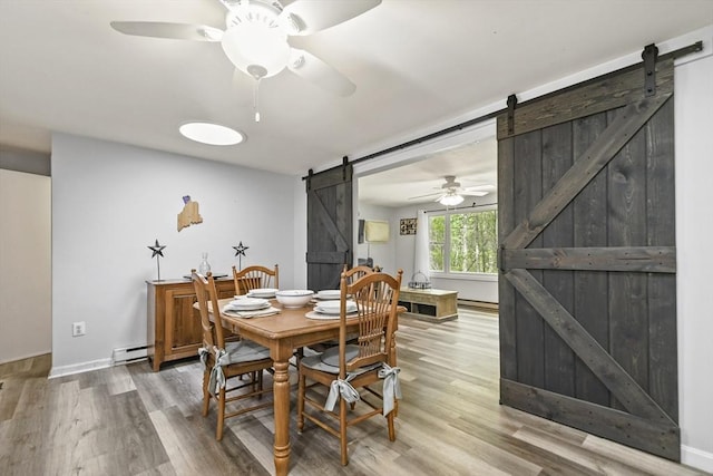 231 Georgetown Rd, Boxford, MA 01921 - dining space featuring a barn door, a ceiling fan, wood finished floors, a baseboard radiator, and baseboards