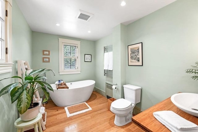 5 Willow Ave, Somerville, MA 02144 - full bathroom featuring toilet, a freestanding tub, wood finished floors, radiator, and recessed lighting