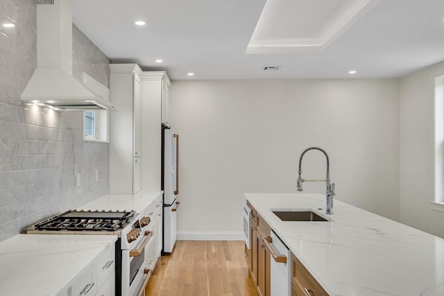 38 Green St Unit 38, Watertown, MA 02472 - kitchen featuring wall chimney range hood, white appliances, recessed lighting, a sink, and light wood-style floors
