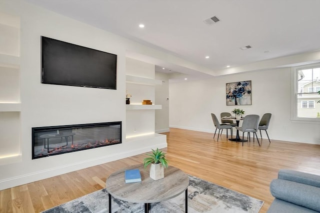 38 Green St Unit 38, Watertown, MA 02472 - living area with wood finished floors, a glass covered fireplace, recessed lighting, and baseboards