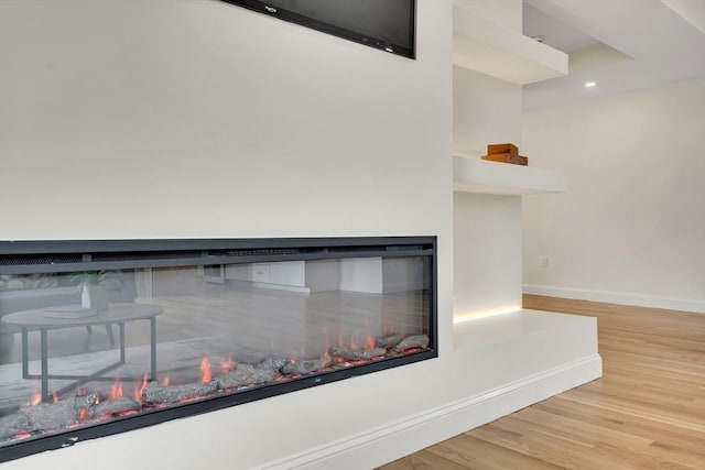 38 Green St Unit 38, Watertown, MA 02472 - detailed view of wood finished floors, baseboards, a glass covered fireplace, and recessed lighting