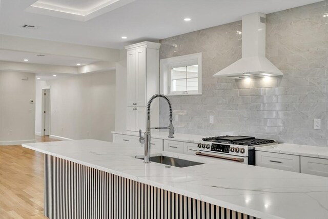 38 Green St Unit 38, Watertown, MA 02472 - kitchen featuring wall chimney exhaust hood, a sink, gas range oven, white cabinets, and light wood finished floors