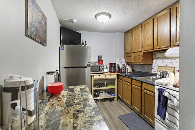 74 Beach St Unit 1-3, Woburn, MA 01801 - kitchen with stainless steel appliances, brown cabinets, dark countertops, a textured ceiling, and backsplash