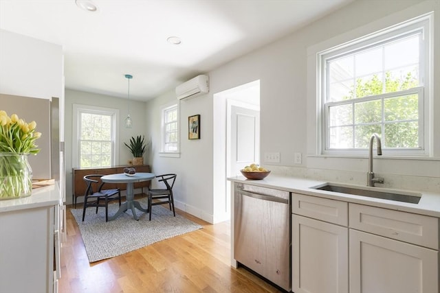 831 Main St, Dennis, MA 02638 - kitchen with dishwasher, an AC wall unit, a sink, light countertops, and light wood finished floors