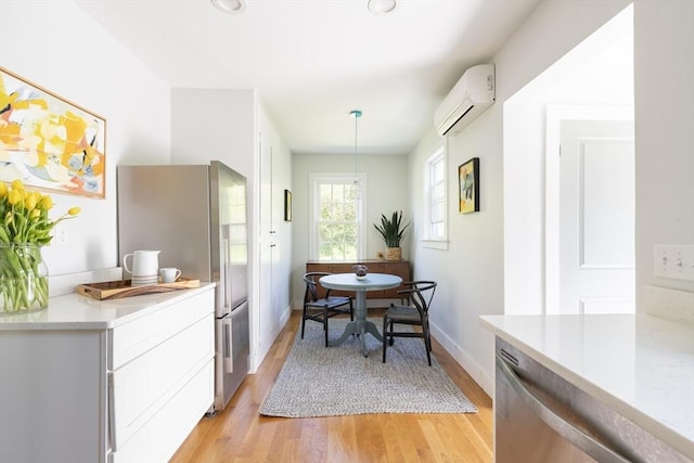 831 Main St, Dennis, MA 02638 - dining room featuring a wall mounted AC, light wood-type flooring, baseboards, and breakfast area