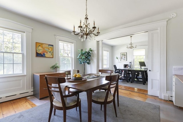 831 Main St, Dennis, MA 02638 - dining space featuring a chandelier, light wood finished floors, and a baseboard heating unit