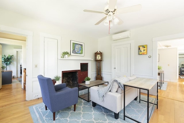 831 Main St, Dennis, MA 02638 - living room featuring a wall mounted AC, light wood-type flooring, a fireplace, and ceiling fan
