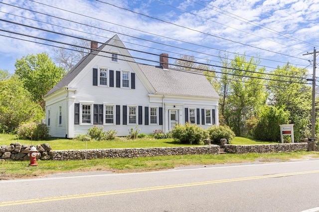 831 Main St, Dennis, MA 02638 - view of front of house featuring a chimney and a front yard