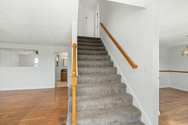 stairs with wood finished floors and baseboards