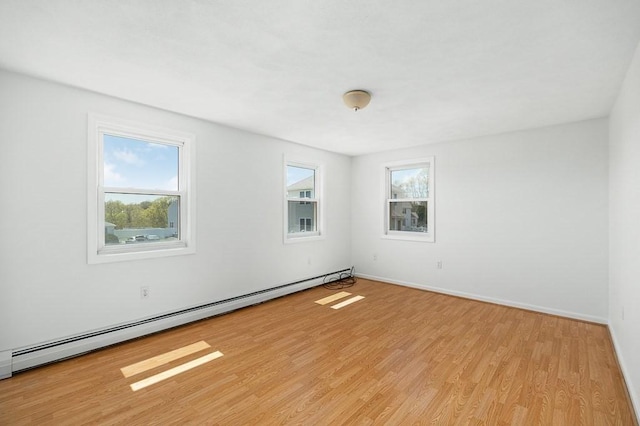 unfurnished room featuring a baseboard radiator, light wood-type flooring, plenty of natural light, and baseboards