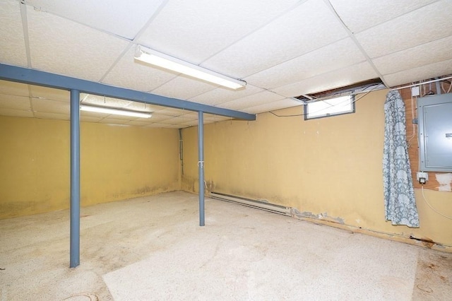 basement featuring a baseboard heating unit, electric panel, and a drop ceiling
