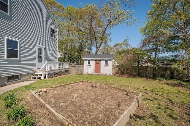 view of yard with a storage unit, a wooden deck, a garden, and an outdoor structure