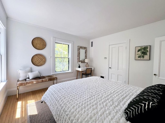 bedroom featuring wood-type flooring, baseboards, and a closet