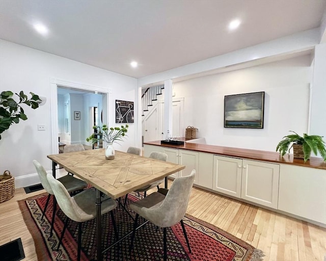 dining space with stairway, light wood-style flooring, and recessed lighting