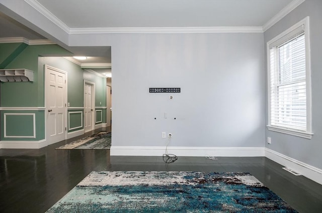 empty room featuring ornamental molding and dark wood-type flooring